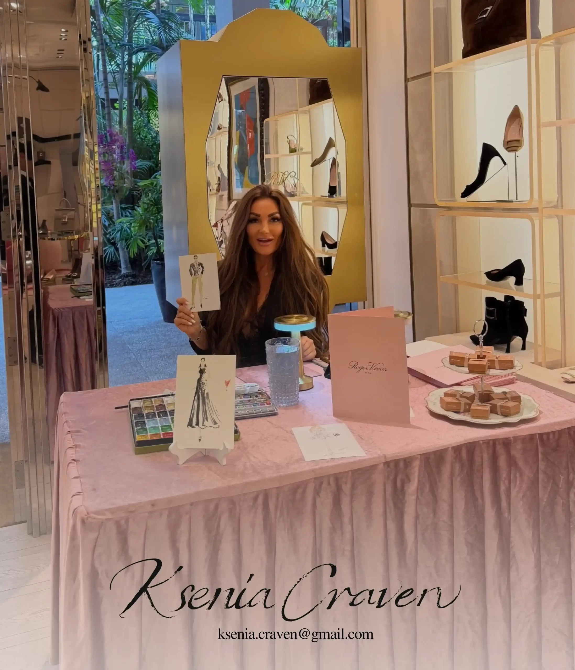 Ksenia Craven holding a watercolor fashion sketch at a live event painting station for Roger Vivier.