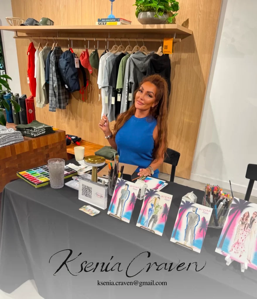 Fashion illustrator Ksenia Craven at a live sketching event with watercolor paintings and art supplies.