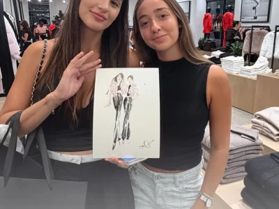 Two women in a retail store holding a custom hand-drawn fashion illustration by Ksenia Craven.